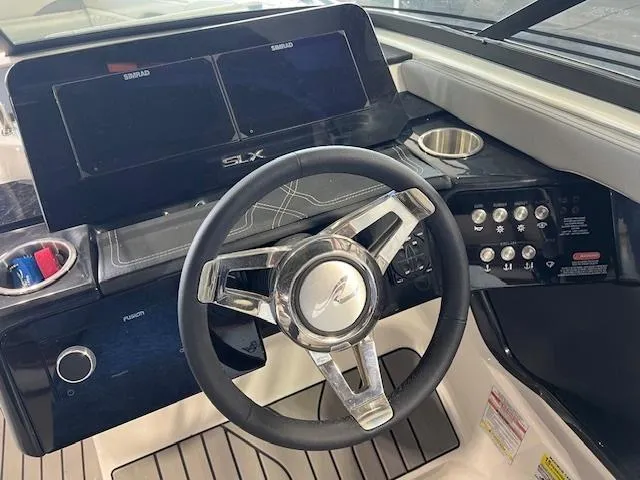 Slide: The Image of 2024 Sea Ray SLX 260 boat dashboard with steering wheel and control panel. - 11