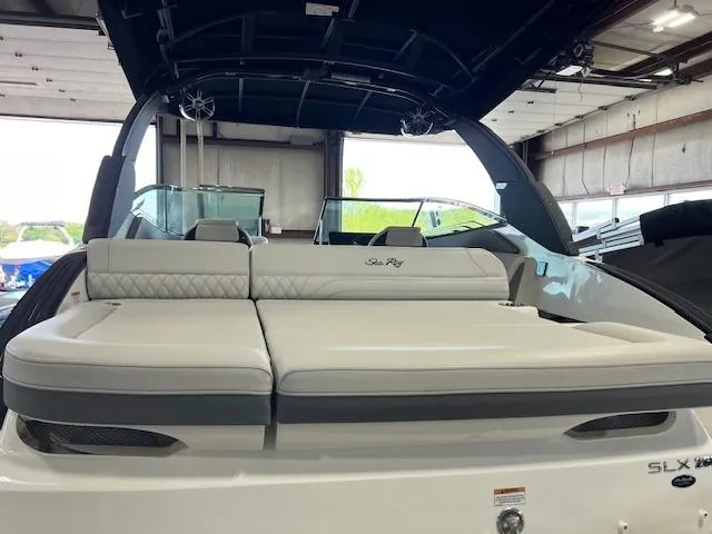 Slide: The Image of 2024 Sea Ray SLX 260 boat with luxurious seating in a showroom. - 2