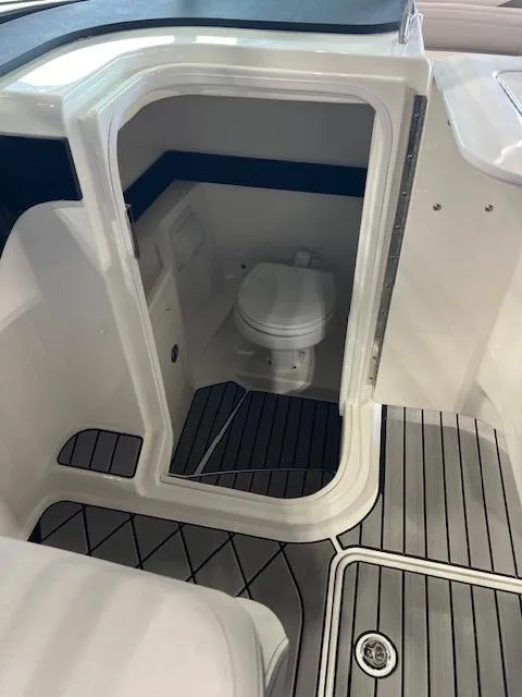 Slide: The Image of 2024 Sea Ray SLX 260 boat interior with a compact marine toilet. - 9