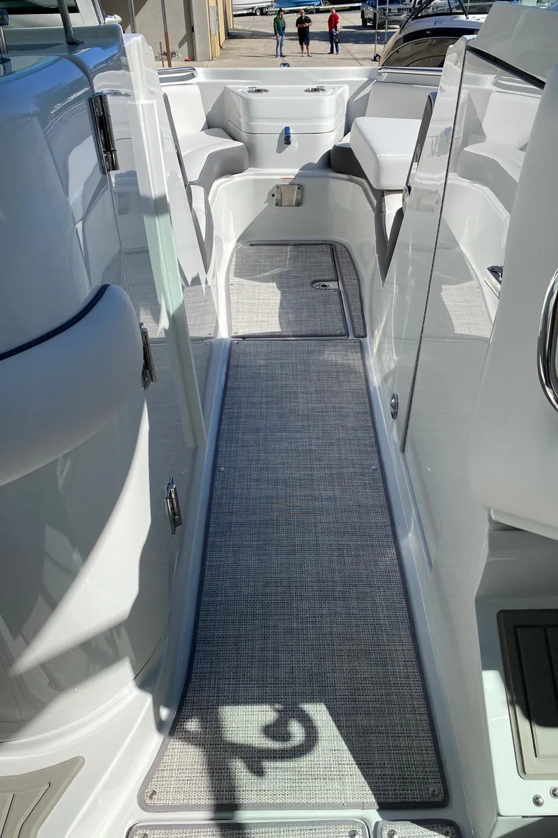 Slide: The Image of 2024 Finseeker 280 DC boat interior walkway with seating and storage compartments. - 15