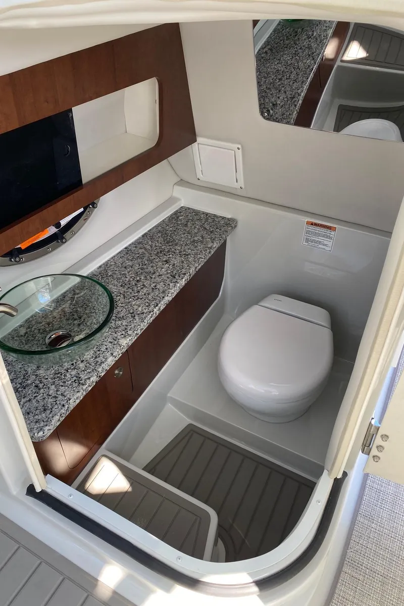 Slide: The Image of 2024 Finseeker 280 DC boat interior bathroom with modern amenities and granite countertop. - 21