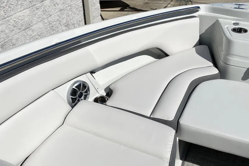 Slide: The Image of 2024 Finseeker 280 DC boat interior with white cushioned seating and built-in speaker. - 24
