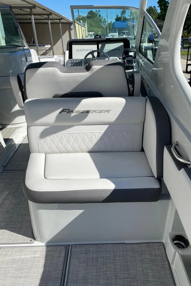 Slide: The Image of 2024 Finseeker 280 DC boat interior with cushioned seating and steering console. - 8