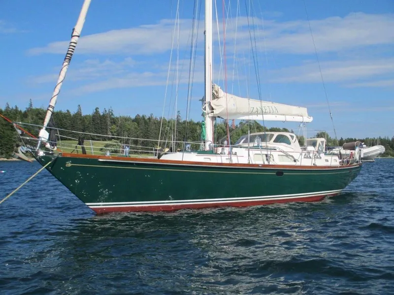 Slide: The Image of 2001 Hinckley Sou'wester 59 CC sailboat on water, green hull, scenic background. - 2