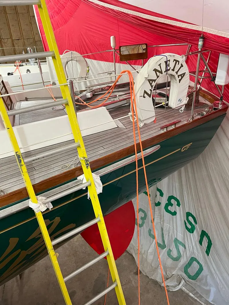 Slide: The Image of Hinckley Sou'wester 59 CC sailboat, 2001 model, in a workshop with red and white sails. - 21