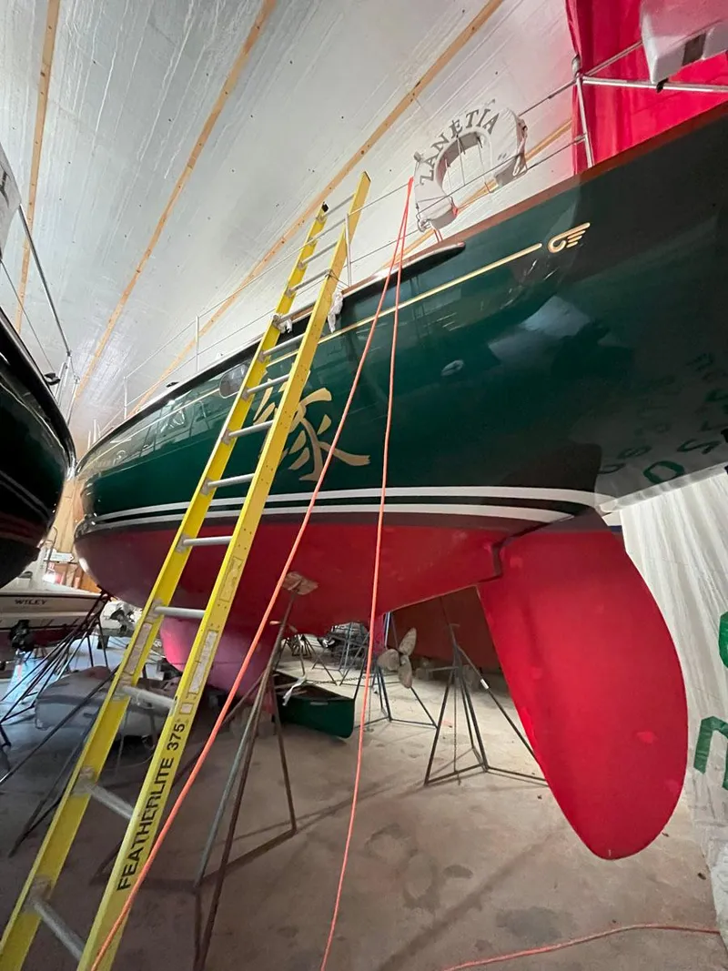 Slide: The Image of 2001 Hinckley Sou'wester 59 CC sailboat in storage, with ladder and red keel visible. - 23