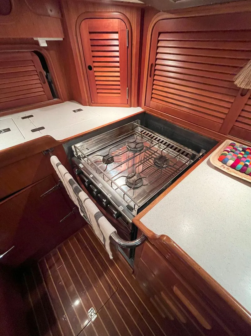 Slide: The Image of Hinckley Sou'wester 59 CC 2001 yacht kitchen with stove and wooden cabinetry. - 32