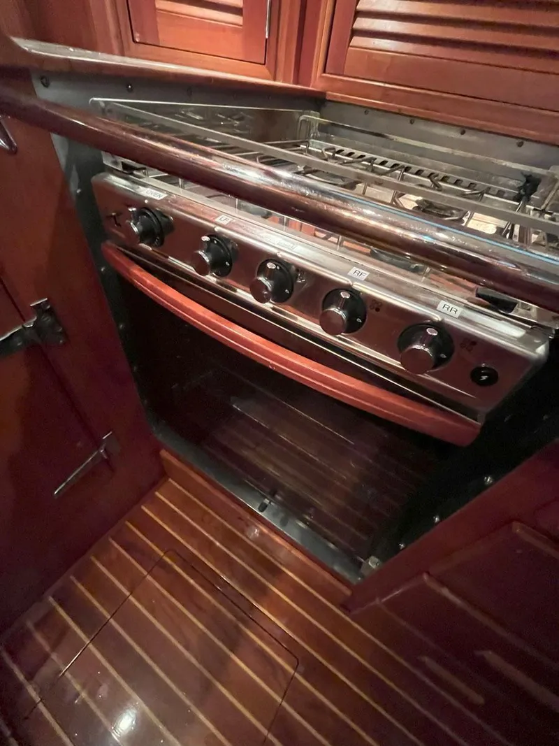 Slide: The Image of Hinckley Sou'wester 59 CC 2001 yacht kitchen with stove and wooden cabinetry. - 33