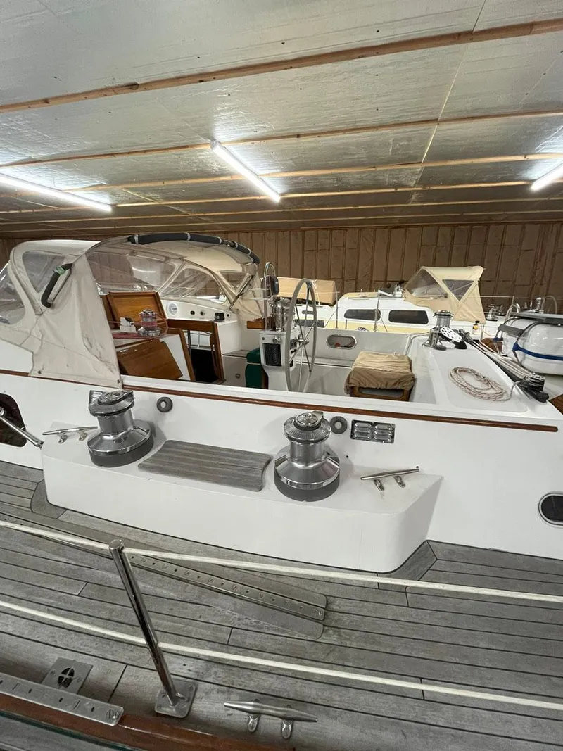 Slide: The Image of 2001 Hinckley Sou'wester 59 CC sailboat in indoor storage, showcasing deck and cockpit. - 13
