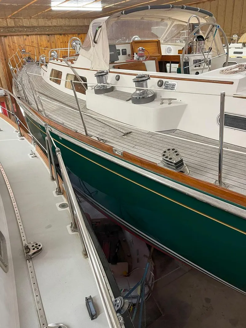 Slide: The Image of Hinckley Sou'wester 59 CC sailboat, 2001 model, docked indoors with green hull and wooden deck. - 19