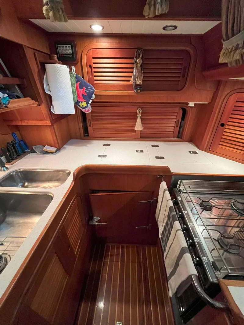 Slide: The Image of 2001 Hinckley Sou'wester 59 CC yacht kitchen with wood cabinetry, dual sink, and stove. - 31