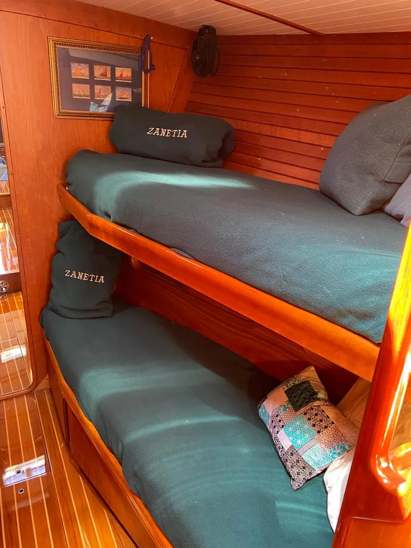 Slide: The Image of Interior of 2001 Hinckley Sou'wester 59 CC with wooden bunk beds and cozy bedding. - 45