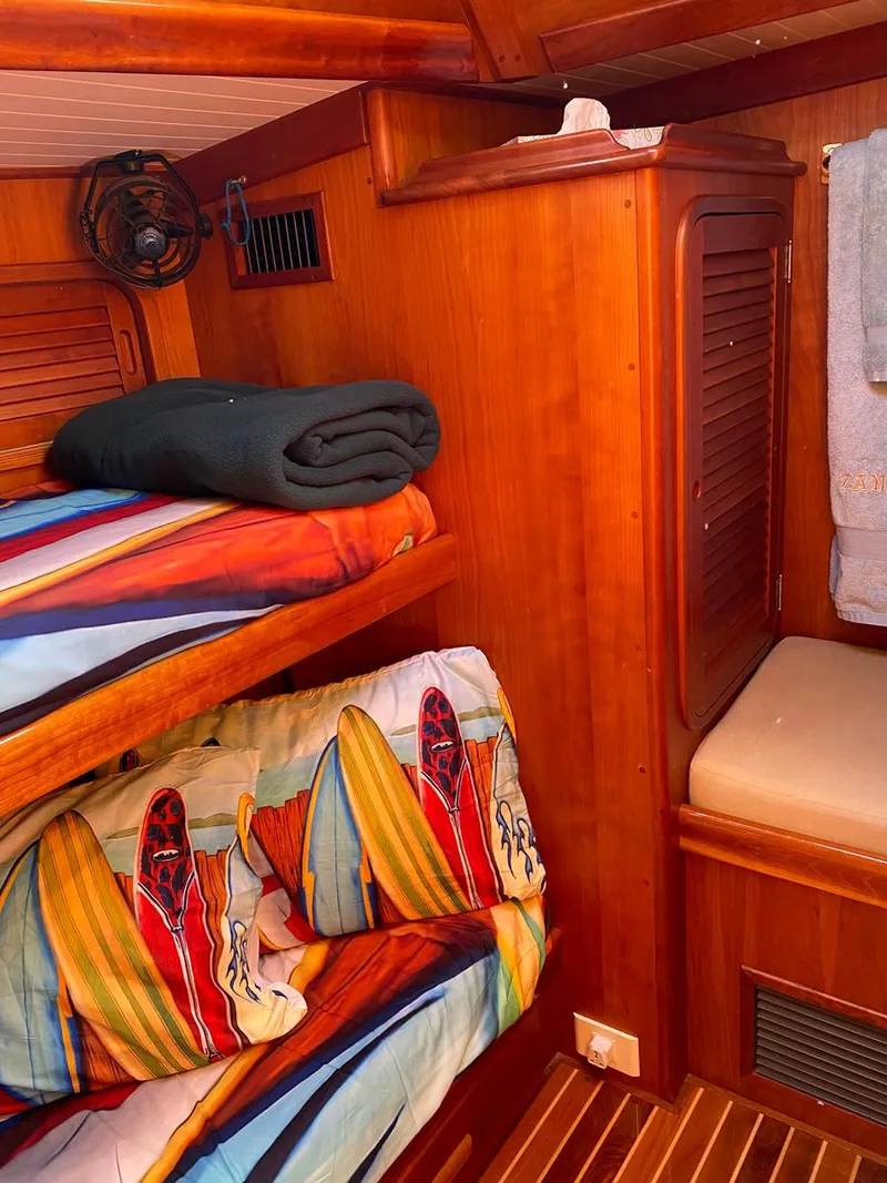 Slide: The Image of Cozy cabin interior of 2001 Hinckley Sou'wester 59 CC with colorful bedding and wooden finishes. - 46