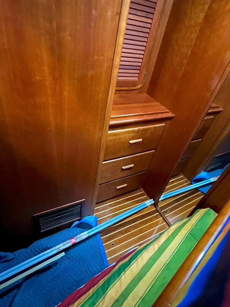 Slide: The Image of Wooden interior of 2001 Hinckley Sou'wester 59 CC sailboat with drawers and colorful bedding. - 49