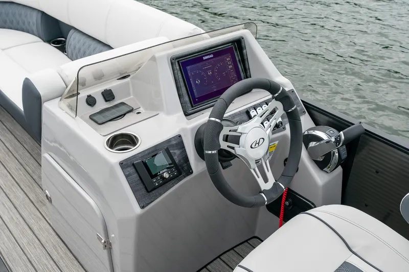 Slide: The Image of 2023 Harris 250 Sunliner Sport boat dashboard with steering wheel and digital display. - 15
