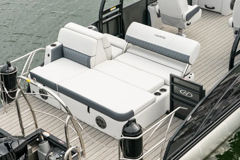 Slide: The Image of 2023 Harris 250 Sunliner Sport pontoon boat with luxurious seating on a lake. - 9