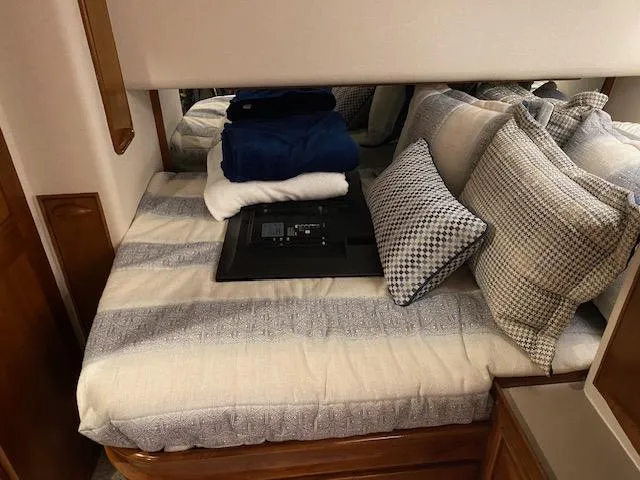 Slide: The Image of Cozy cabin bed in a 1984 Custom Carolina Buddy Davis boat with folded linens and pillows. - 23