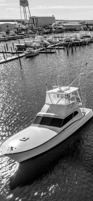 Slide: The Image of 1984 Custom Carolina Buddy Davis boat cruising in a marina with other boats docked. - 3