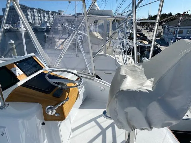 Slide: The Image of 1984 Custom Carolina Buddy Davis boat helm with covered captain's chair and marina view. - 50