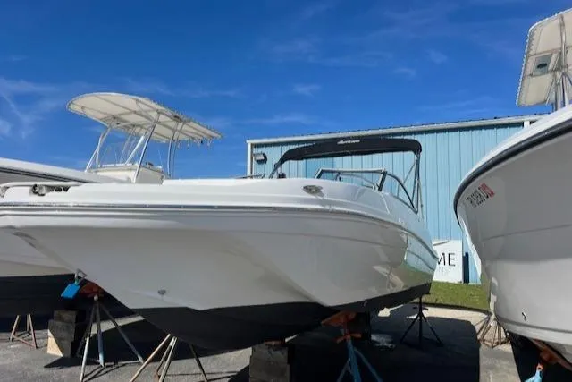 Slide: The Image of 2018 Hurricane SunDeck 2200 DC OB boat on stands, blue sky background. - 1