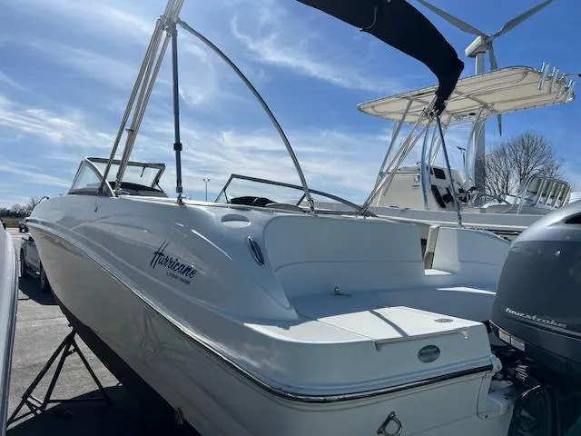 Slide: The Image of 2018 Hurricane SunDeck 2200 DC OB boat, white exterior, docked under a clear blue sky. - 4