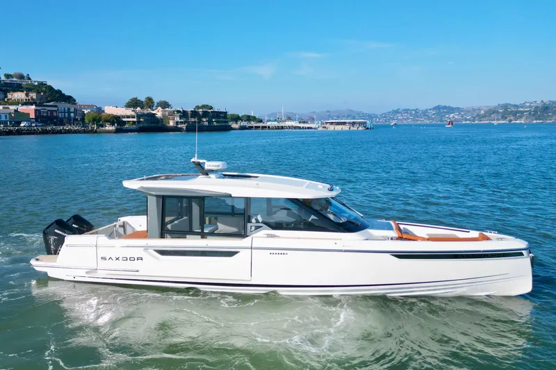The Image of 2026 Saxdor 400 GTC boat cruising on a sunny day near coastal town. - 0