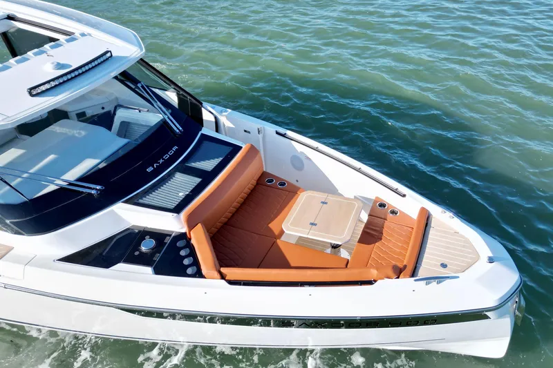Slide: The Image of 2026 Saxdor 400 GTC boat with luxurious seating and table on calm water. - 15