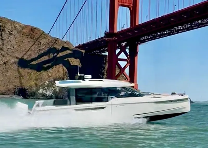 Slide: The Image of 2026 Saxdor 400 GTC cruising under a red bridge in scenic waters. - 18