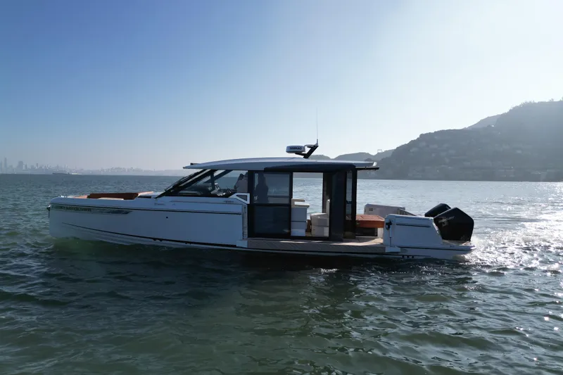 Slide: The Image of 2026 Saxdor 400 GTC boat cruising on a sunny day near a coastal city. - 21