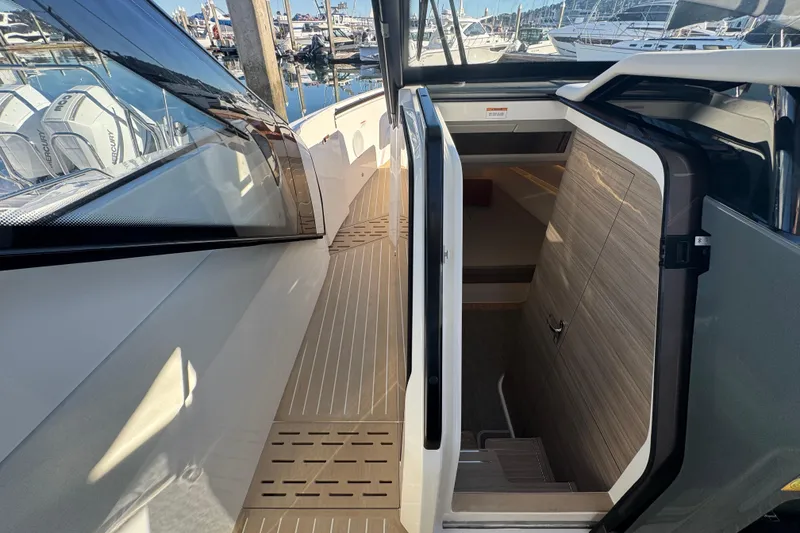 Slide: The Image of 2026 Saxdor 400 GTC boat interior with open cabin door, docked at marina. - 43