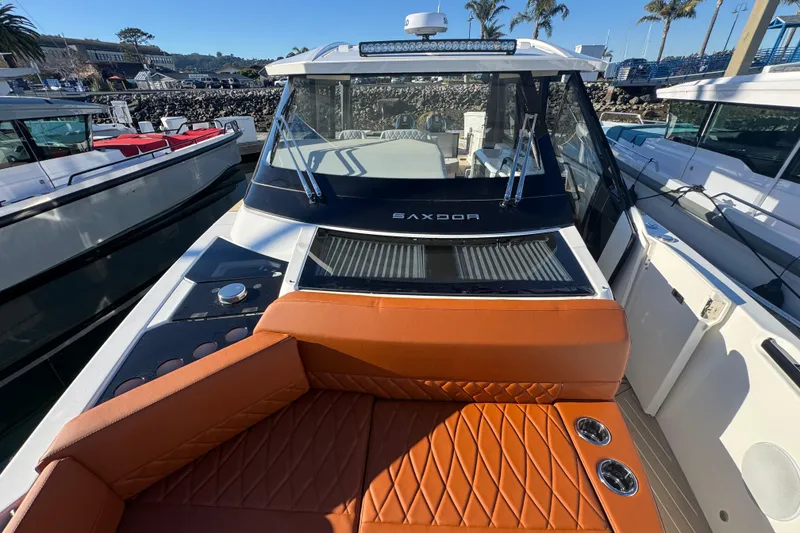 Slide: The Image of 2026 Saxdor 400 GTC boat with orange seating and sleek design at a marina. - 54