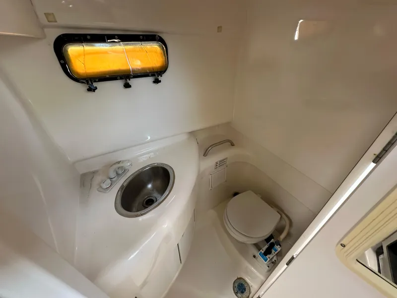Slide: The Image of 1998 Trophy 2902 Walkaround boat bathroom with sink and toilet. - 15