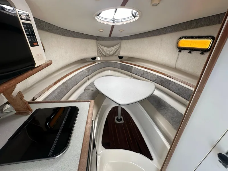 Slide: The Image of 1998 Trophy 2902 Walkaround cabin interior with seating and kitchenette. - 19