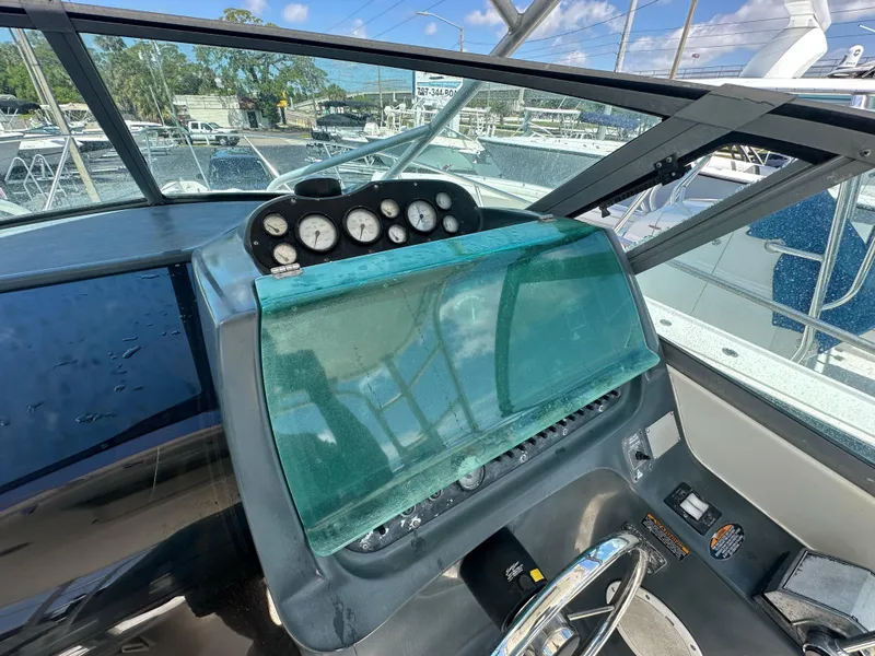 Slide: The Image of 1998 Trophy 2902 Walkaround boat dashboard with gauges and steering wheel. - 21
