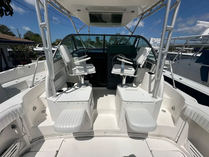 Slide: The Image of 1998 Trophy 2902 Walkaround boat cockpit with dual captain chairs and white seating. - 7
