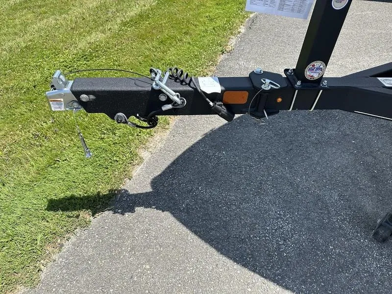 Slide: The Image of 2024 Tahoe 200 S boat trailer hitch on pavement near grass. - 4