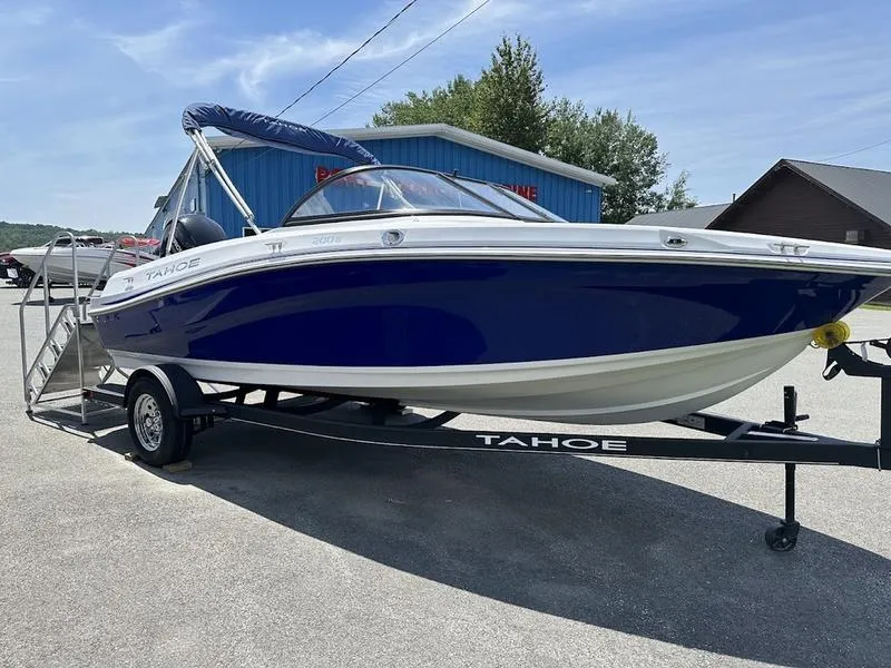 Slide: The Image of 2024 Tahoe 200 S boat on trailer, blue and white, parked outdoors. - 8