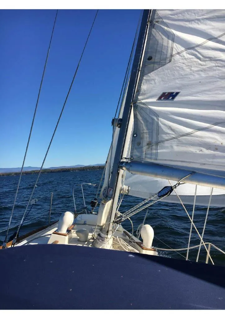 Slide: The Image of Sailing on a 1974 Tartan 30 yacht with clear blue skies and calm waters. - 1