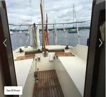 Slide: The Image of 1974 Tartan 30 sailboat cockpit with wooden deck, overlooking a serene marina. - 10