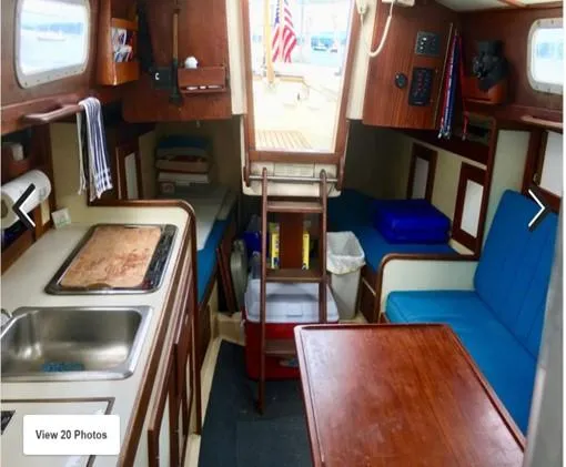 Slide: The Image of Interior of a 1974 Tartan 30 sailboat with kitchen, seating, and wooden accents. - 12