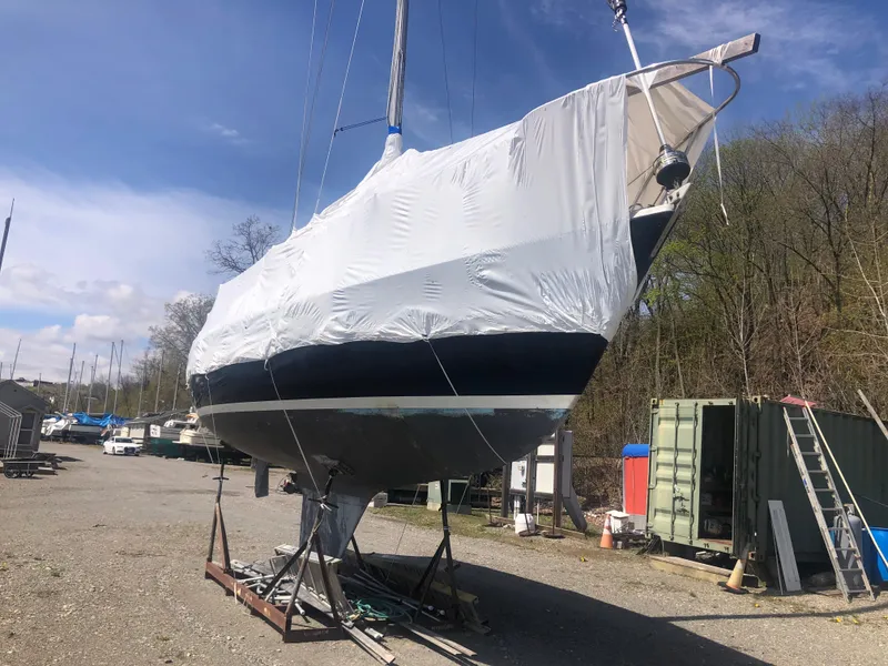 Slide: The Image of 1974 Tartan 30 sailboat covered in protective wrap, stored outdoors on a sunny day. - 15