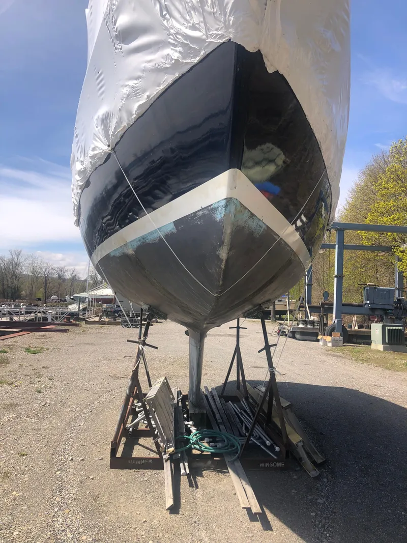 Slide: The Image of 1974 Tartan 30 sailboat on stands, under maintenance, with clear blue sky background. - 20