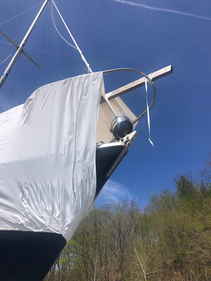 Slide: The Image of 1974 Tartan 30 sailboat with protective cover against a clear blue sky. - 21