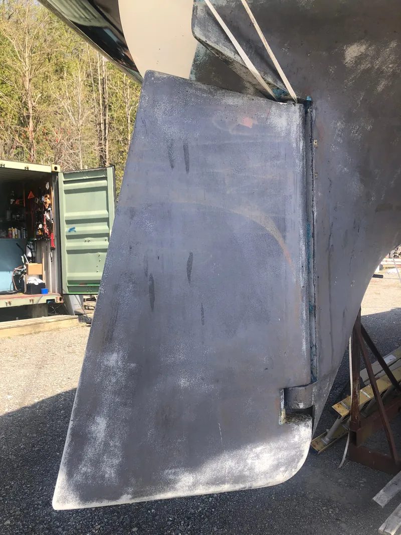 Slide: The Image of Rudder of a 1974 Tartan 30 sailboat, displayed outdoors near a storage container. - 23