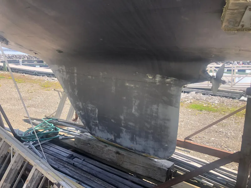 Slide: The Image of 1974 Tartan 30 sailboat keel on dry dock, showing wear and maintenance needs. - 26