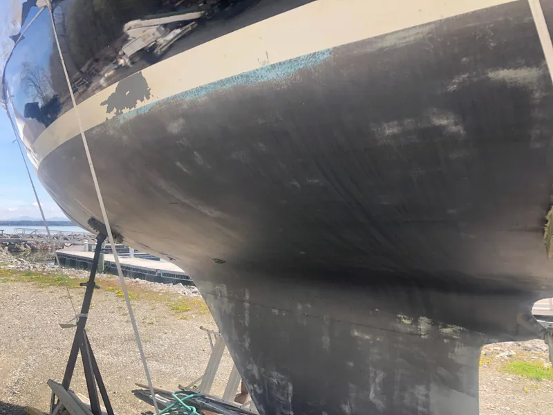 Slide: The Image of 1974 Tartan 30 sailboat hull on dry dock, showing wear and maintenance needs. - 27
