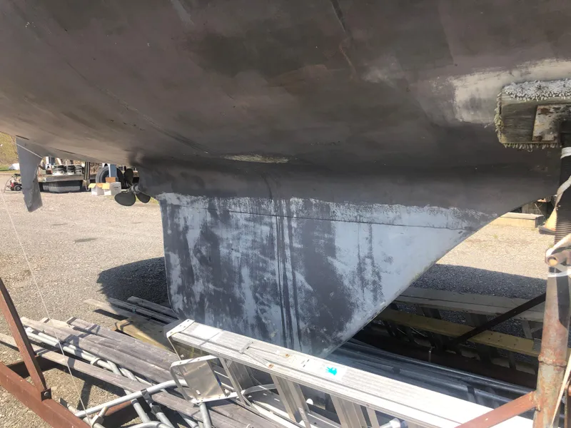 Slide: The Image of 1974 Tartan 30 sailboat keel on dry dock, showing hull and rudder details. - 28