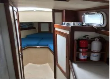 Slide: The Image of 1974 Tartan 30 sailboat interior with blue cushions and safety equipment. - 8