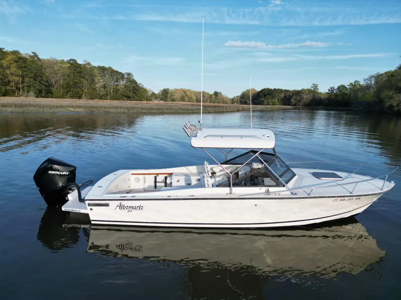 Slide: The Image of 1988 Albemarle 24 boat on calm river with trees in background. - 2