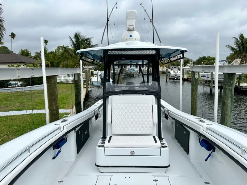 Slide: The Image of 2024 Yellowfin 36 boat with white seating and fishing rods, docked in a marina. - 16